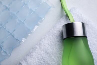 Bottle of water, ice pack and towel on white background, flat lay. Heat stroke treatment Photo of Bottle of water, ice pack and towel on white background, flat lay. Heat stroke treatment