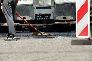 Worker laying new asphalt with paver, closeup. Road repair Photo of Worker laying new asphalt with paver, closeup. Road repair
