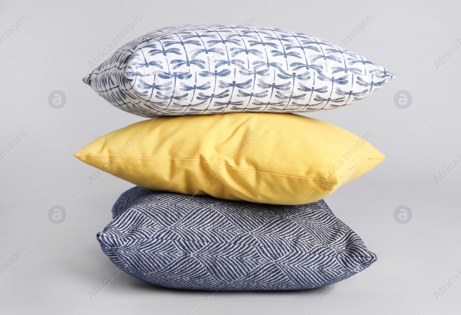 Photo of Stack of stylish soft pillows on grey background