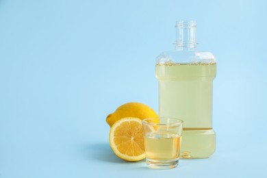 Mouthwash and fresh lemon on light blue background, space for text Photo of Mouthwash and fresh lemon on light blue background, space for text