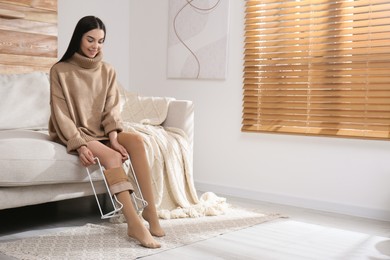 Woman wearing compression tights with donner in living room. Space for text Photo of Woman wearing compression tights with donner in living room. Space for text