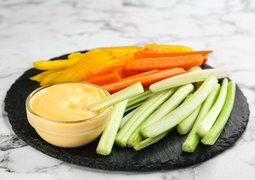 Celery and other vegetable sticks with dip sauce on white marble table Photo of Celery and other vegetable sticks with dip sauce on white marble table