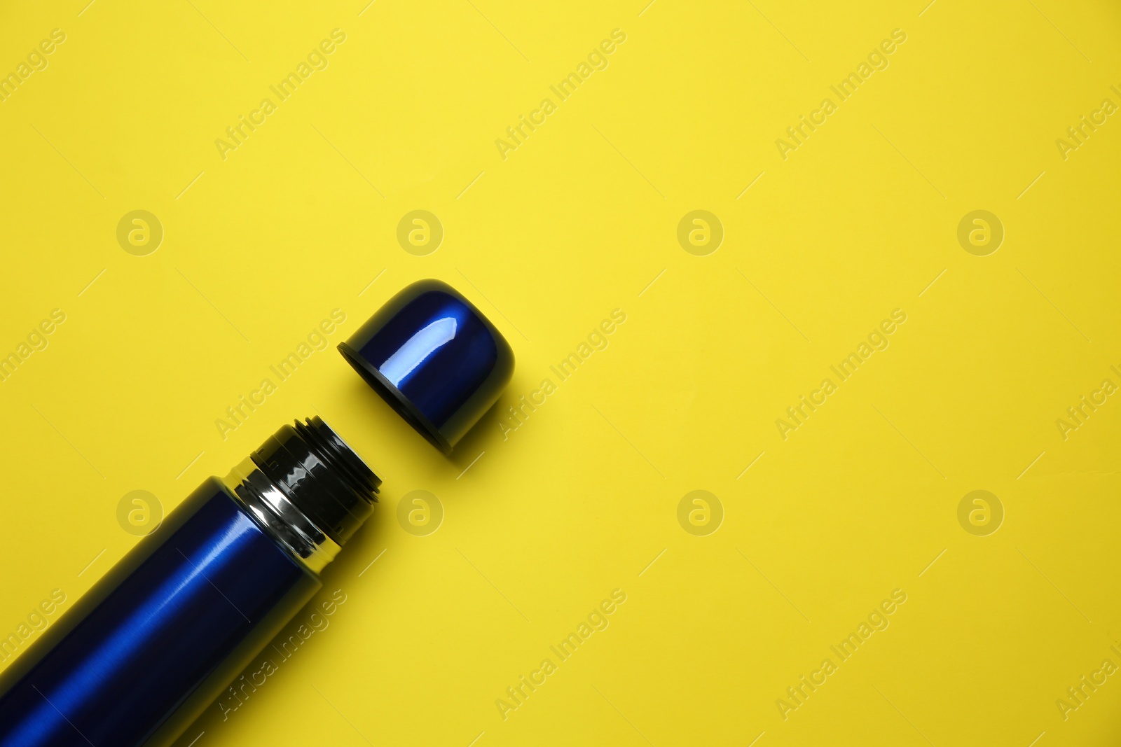 New modern thermos and cup on yellow background, flat lay. Space for text Photo of New modern thermos and cup on yellow background, flat lay. Space for text