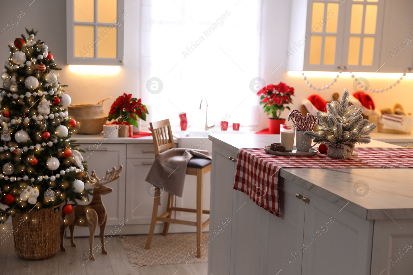 Beautiful kitchen interior with Christmas tree and festive decor Photo of Beautiful kitchen interior with Christmas tree and festive decor