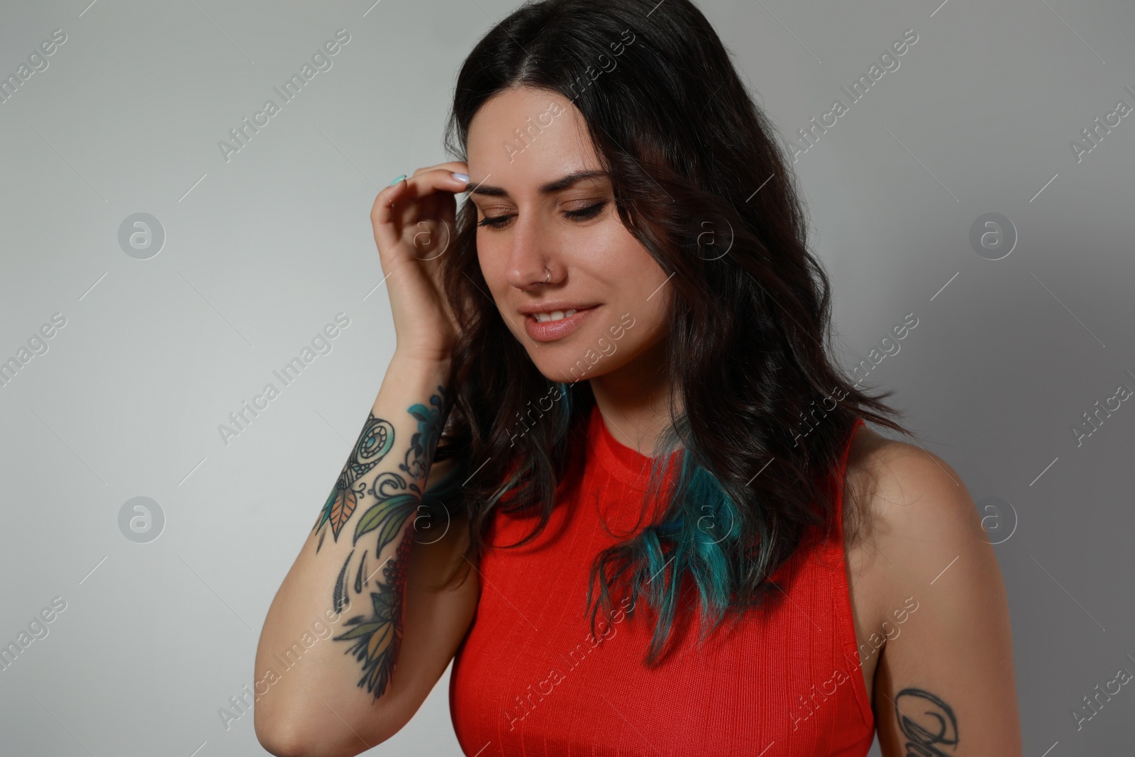 Photo of Beautiful young woman with nose piercing on grey background