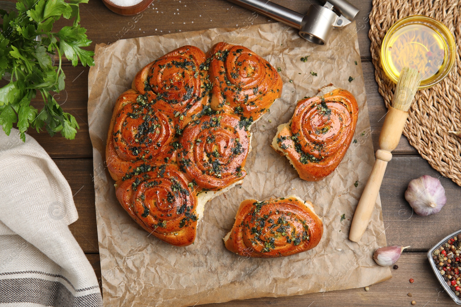 Photo of Traditional Ukrainian bread (Pampushky) with garlic  on wooden table, flat lay