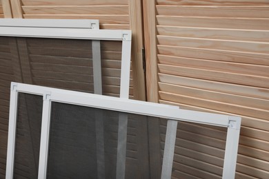 Set of window screens near wooden folding screen Photo of Set of window screens near wooden folding screen