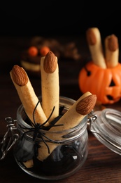 Delicious desserts decorated as monster fingers on wooden table. Halloween treat Photo of Delicious desserts decorated as monster fingers on wooden table. Halloween treat
