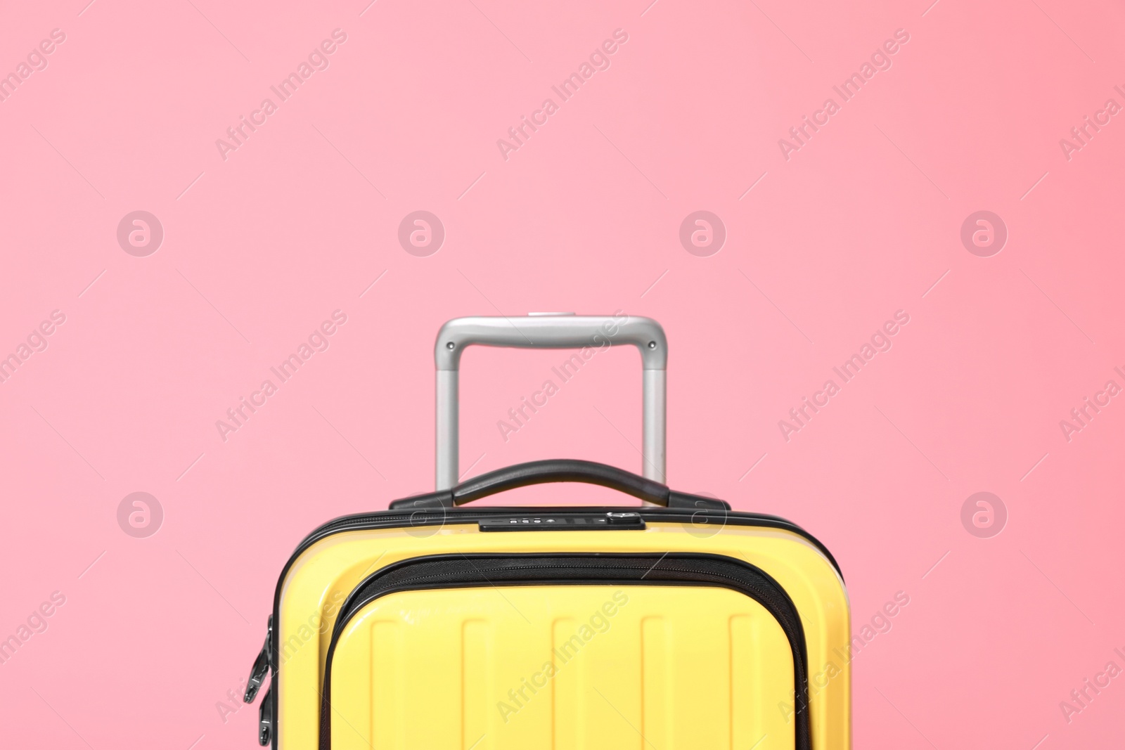 Stylish yellow suitcase packed for travel on pink background Photo of Stylish yellow suitcase packed for travel on pink background