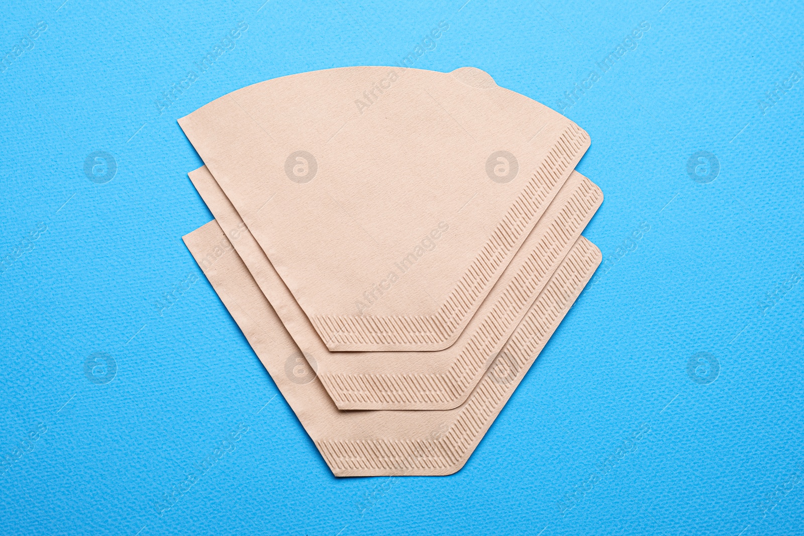 Paper coffee filters on light blue background, flat lay Photo of Paper coffee filters on light blue background, flat lay
