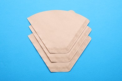 Paper coffee filters on light blue background, flat lay Photo of Paper coffee filters on light blue background, flat lay