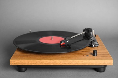 Modern vinyl record player with disc on grey background Photo of Modern vinyl record player with disc on grey background