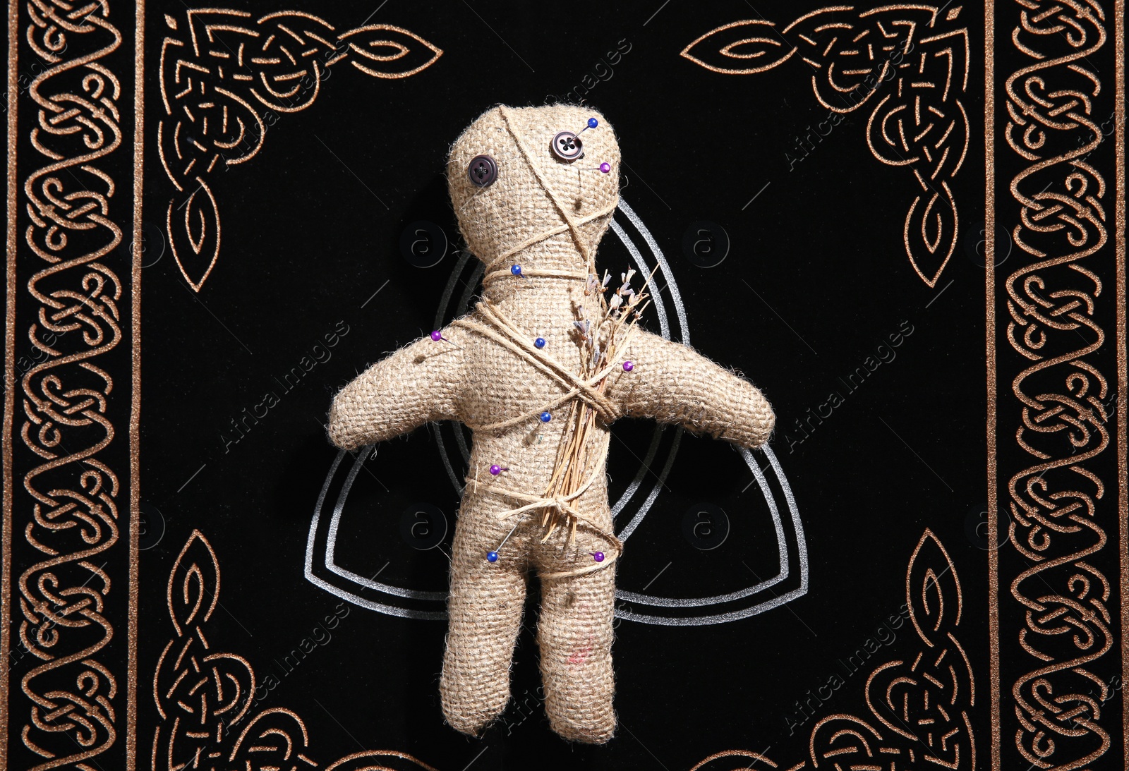 Voodoo doll pierced with pins on table, top view. Curse ceremony Photo of Voodoo doll pierced with pins on table, top view. Curse ceremony