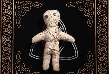 Voodoo doll pierced with pins on table, top view. Curse ceremony Photo of Voodoo doll pierced with pins on table, top view. Curse ceremony