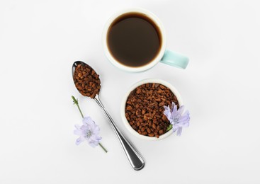 Photo of Cup of delicious chicory drink, granules and flowers on white background, top view