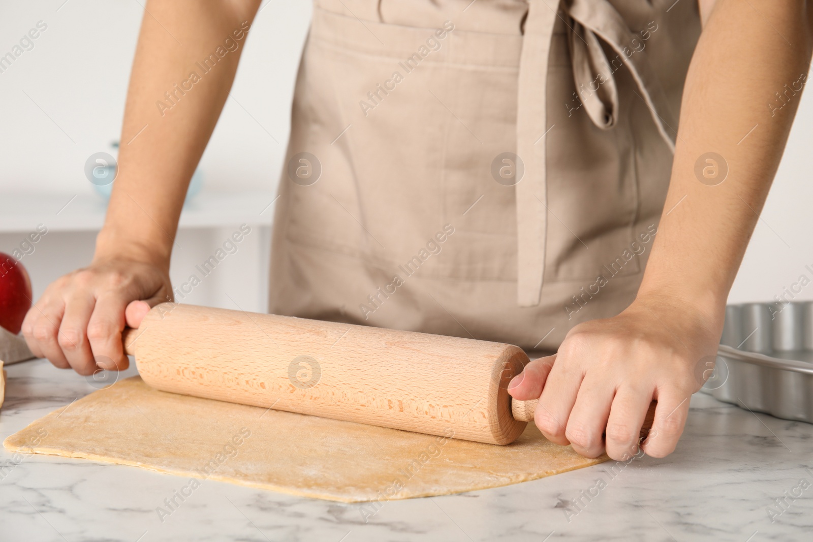 Woman rolling dough for traditional English apple pie at white marble table, closeup Photo of Woman rolling dough for traditional English apple pie at white marble table, closeup