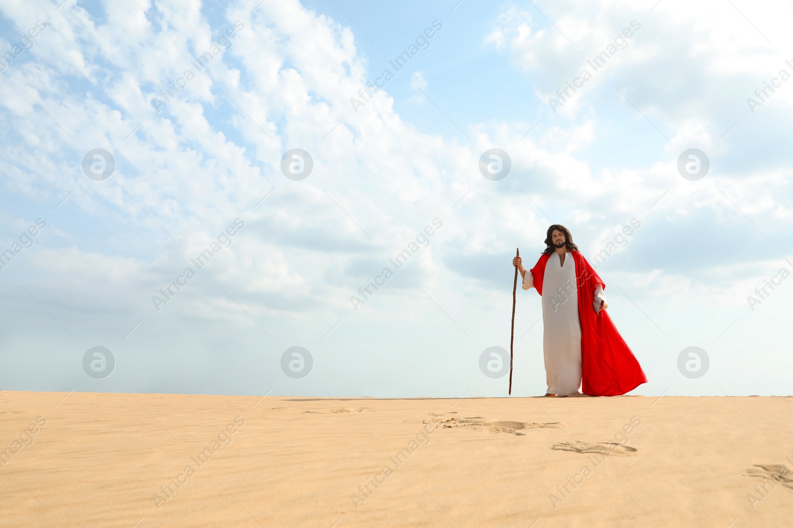 Jesus Christ walking with stick in desert. Space for text Photo of Jesus Christ walking with stick in desert. Space for text