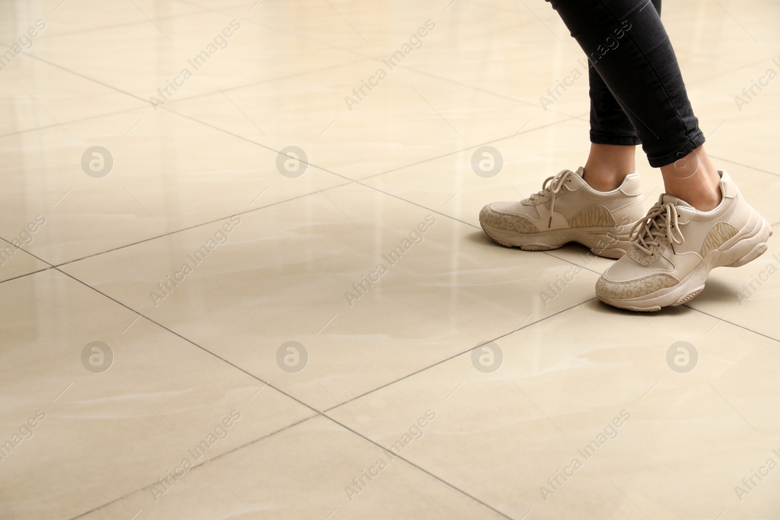 Woman standing on ceramic floor, closeup. Space for text Photo of Woman standing on ceramic floor, closeup. Space for text
