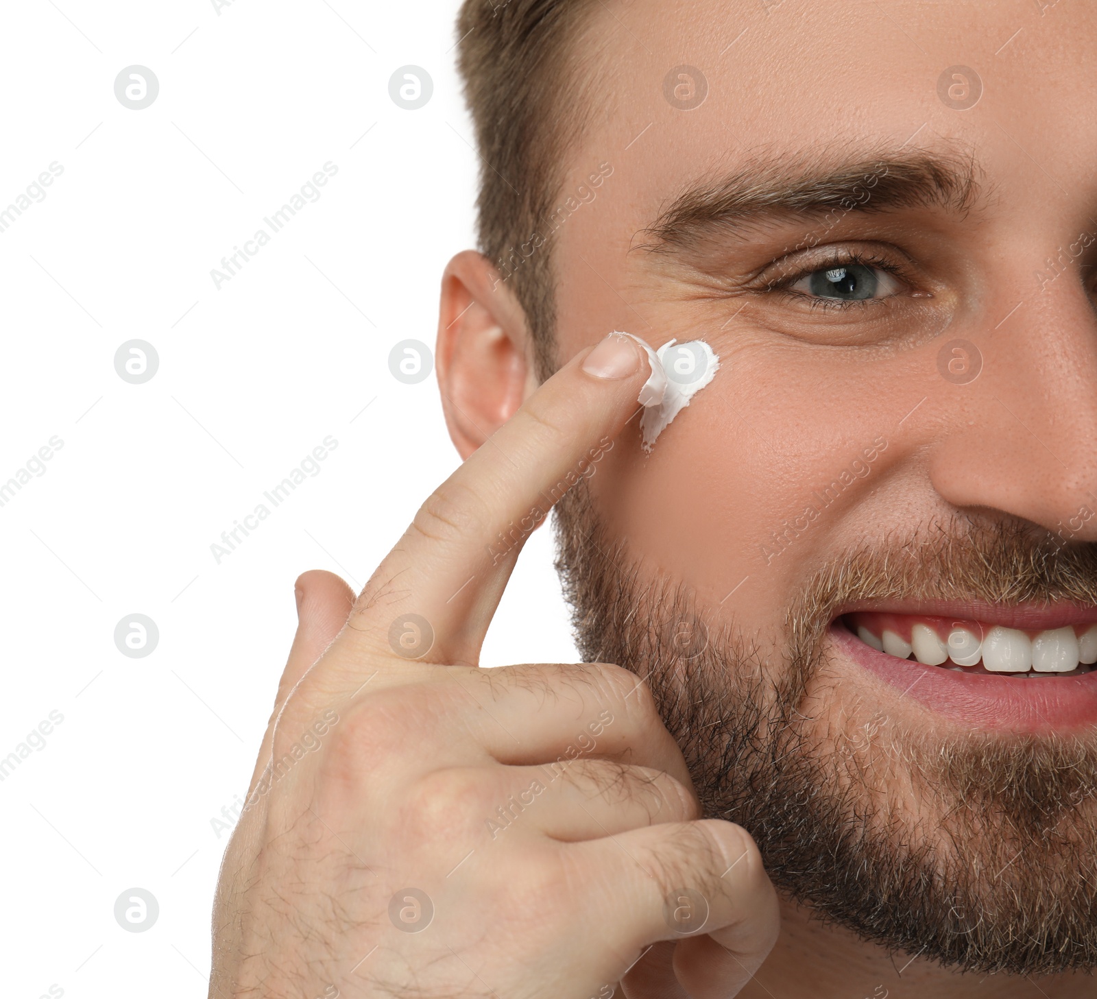 Happy young man applying facial cream on white background, closeup Photo of Happy young man applying facial cream on white background, closeup