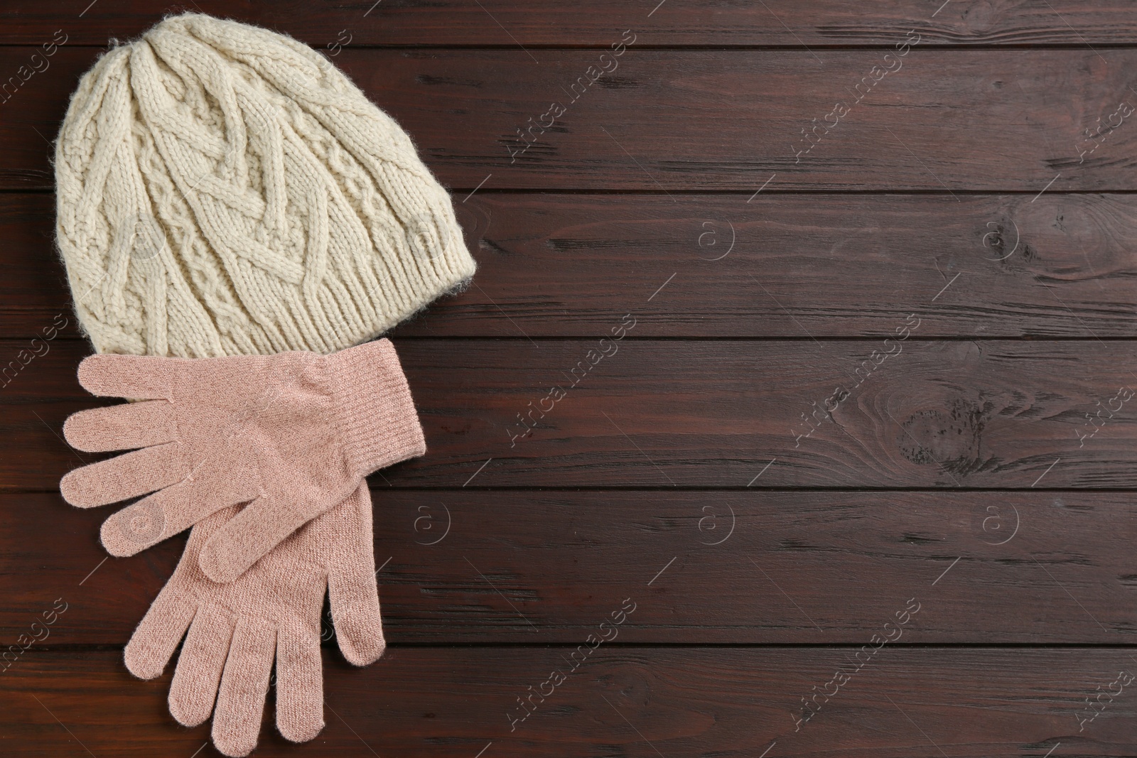 Stylish gloves and hat on wooden background, flat lay. Space for text Photo of Stylish gloves and hat on wooden background, flat lay. Space for text