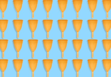Image of Many orange menstrual cups on turquoise background, flat lay. Pattern design