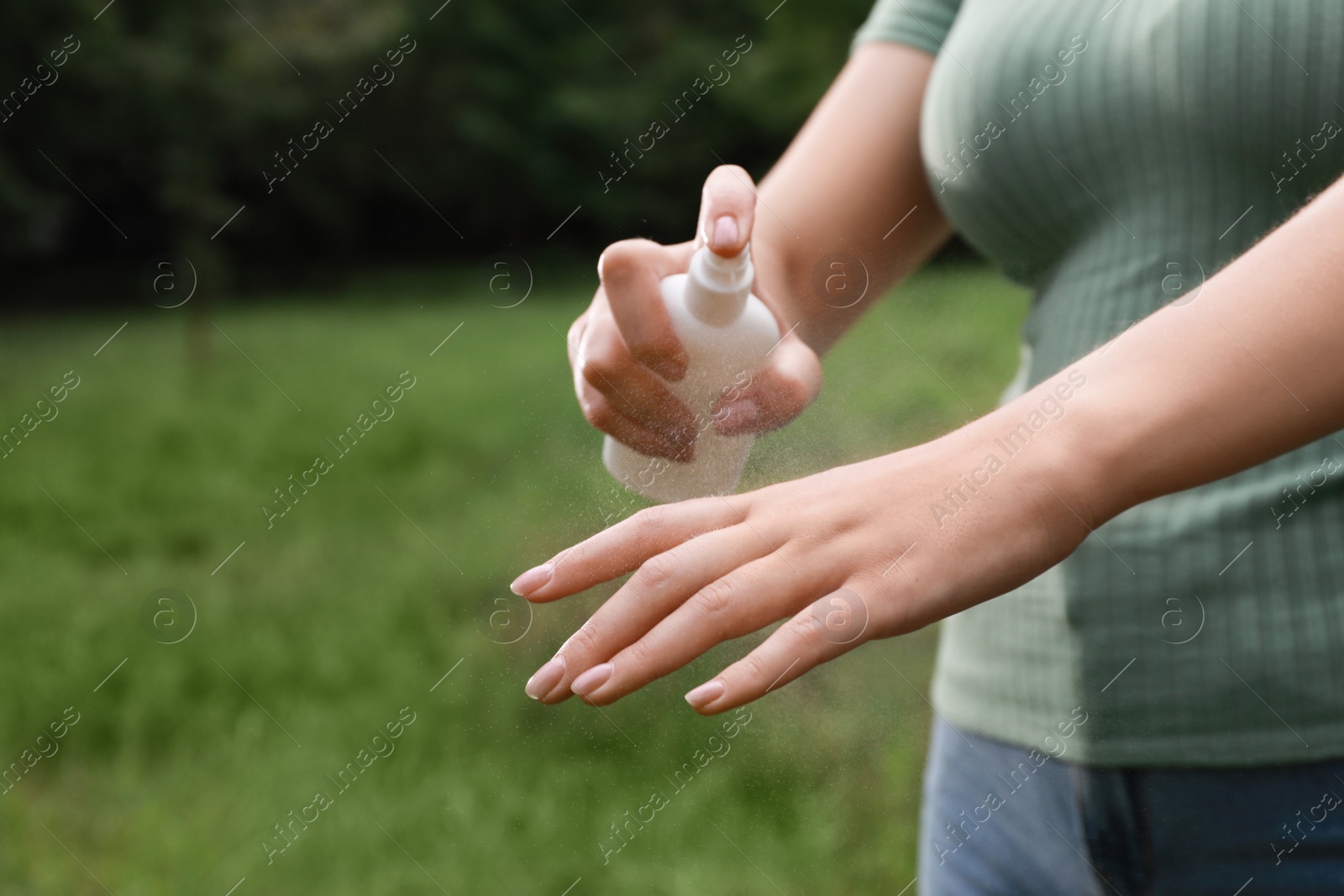 Woman applying insect repellent onto hand in park, closeup. Tick bites prevention Photo of Woman applying insect repellent onto hand in park, closeup. Tick bites prevention