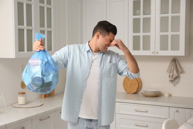 Man holding full garbage bag at home Photo of Man holding full garbage bag at home