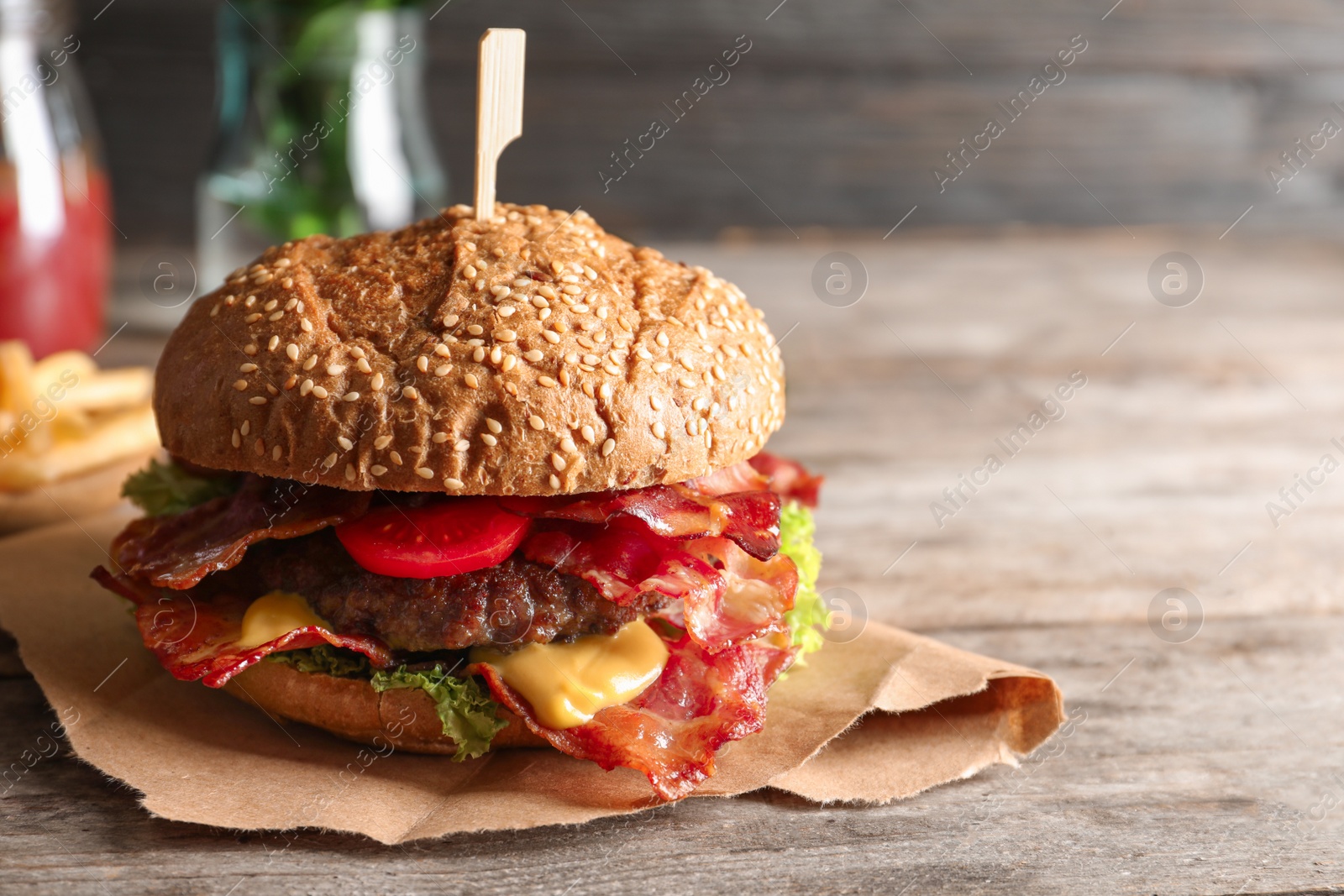 Tasty burger with bacon on wooden table Photo of Tasty burger with bacon on wooden table
