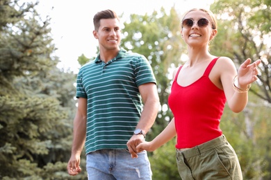 Lovely couple walking together in park on sunny day Photo of Lovely couple walking together in park on sunny day