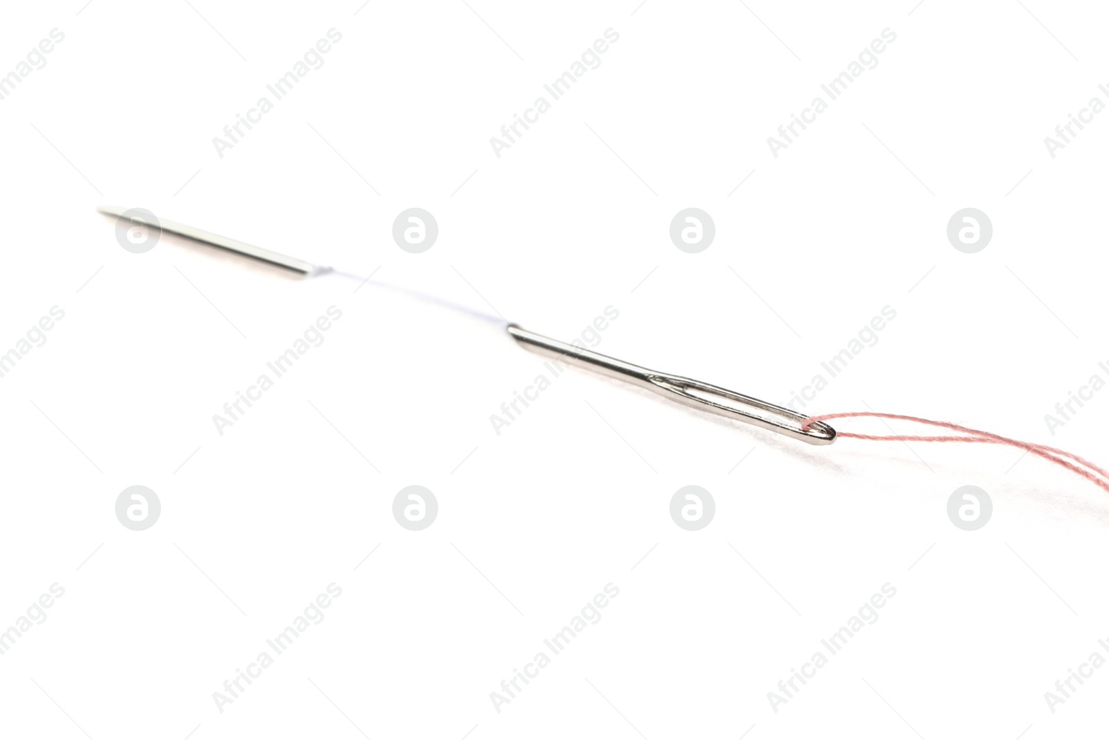 Photo of Sewing needle with thread piercing white paper