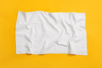 Crumpled white beach towel on yellow background, top view Photo of Crumpled white beach towel on yellow background, top view