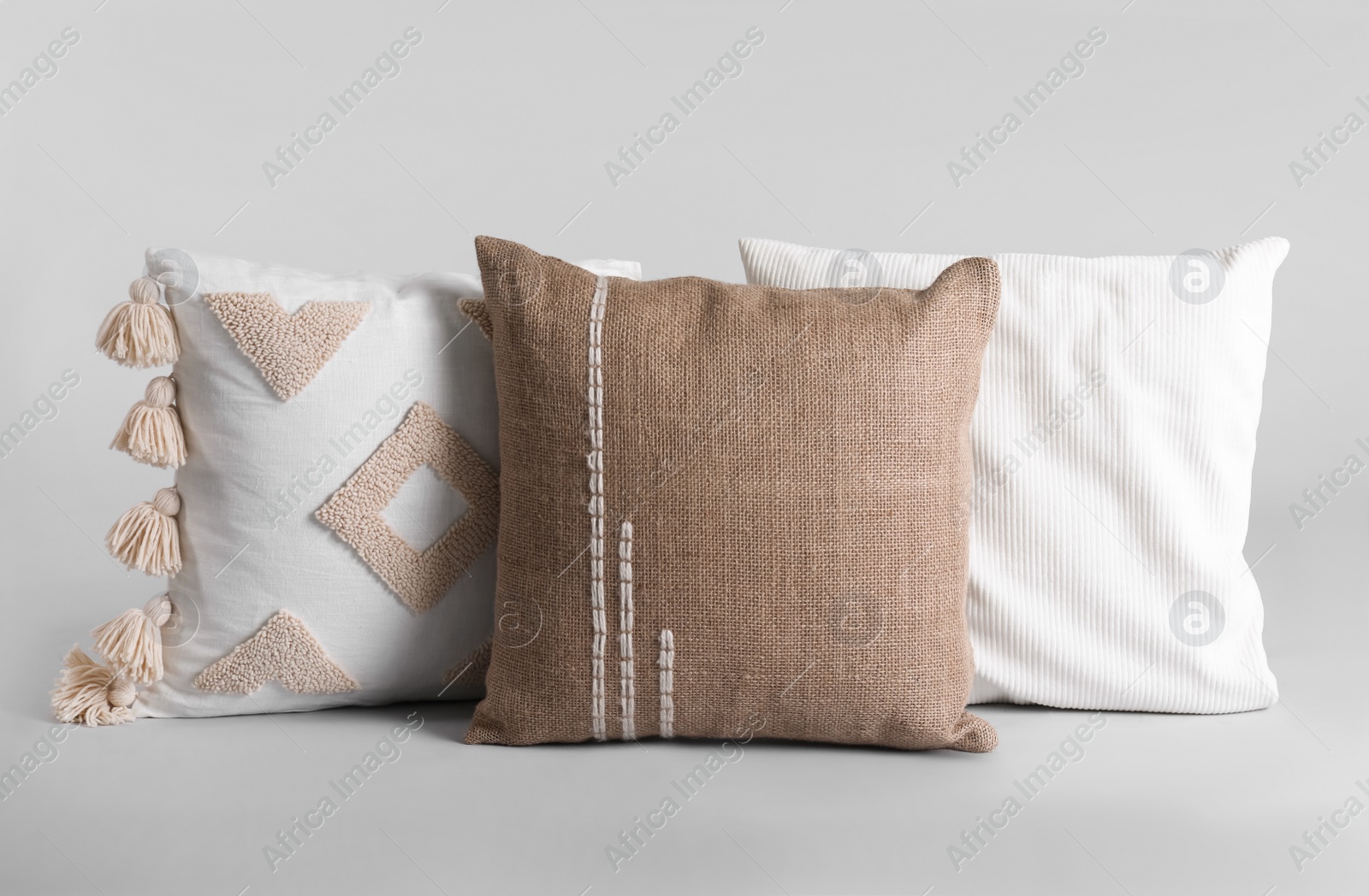 Photo of Different stylish soft pillows on grey background