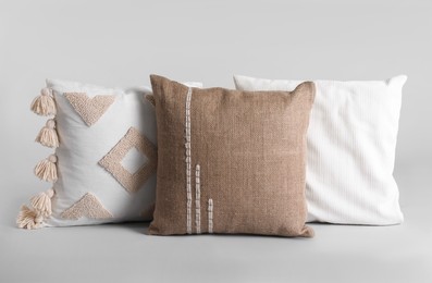 Different stylish soft pillows on grey background Photo of Different stylish soft pillows on grey background