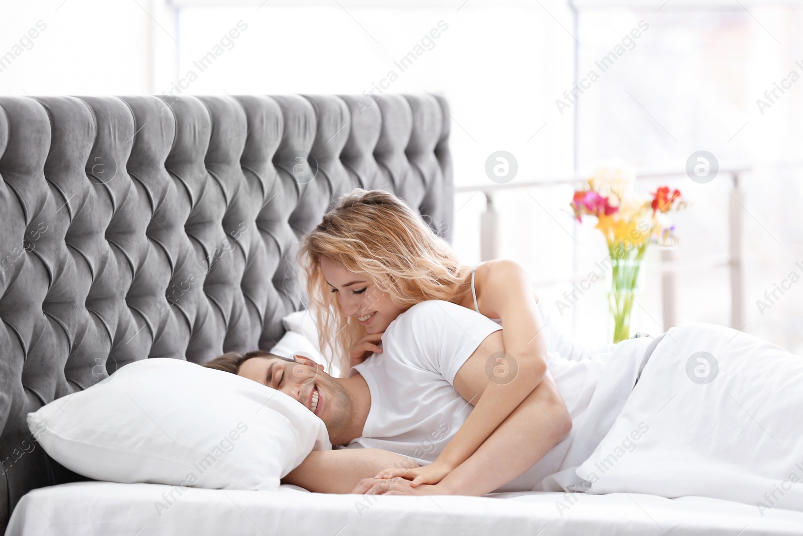 Lovely young woman hugging her boyfriend in bed at home Photo of Lovely young woman hugging her boyfriend in bed at home