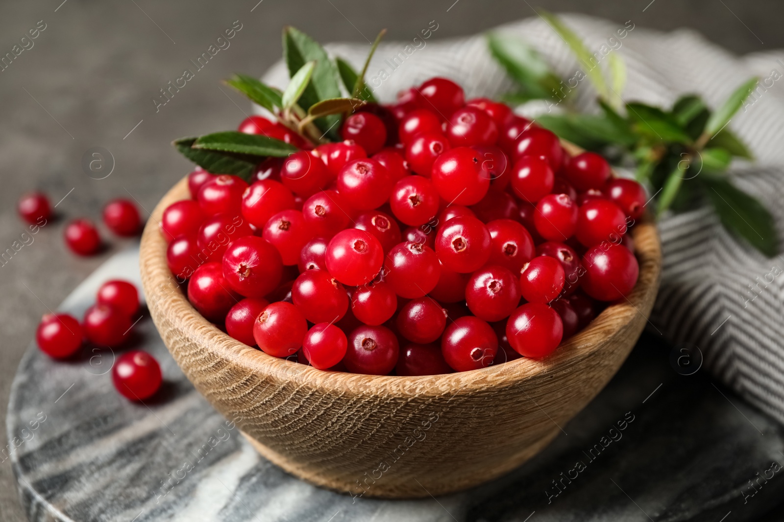 Tasty ripe cranberries on grey marble board, closeup Photo of Tasty ripe cranberries on grey marble board, closeup