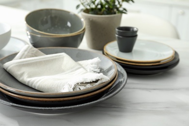 Photo of Set of beautiful ceramic tableware on white table in kitchen. Space for text