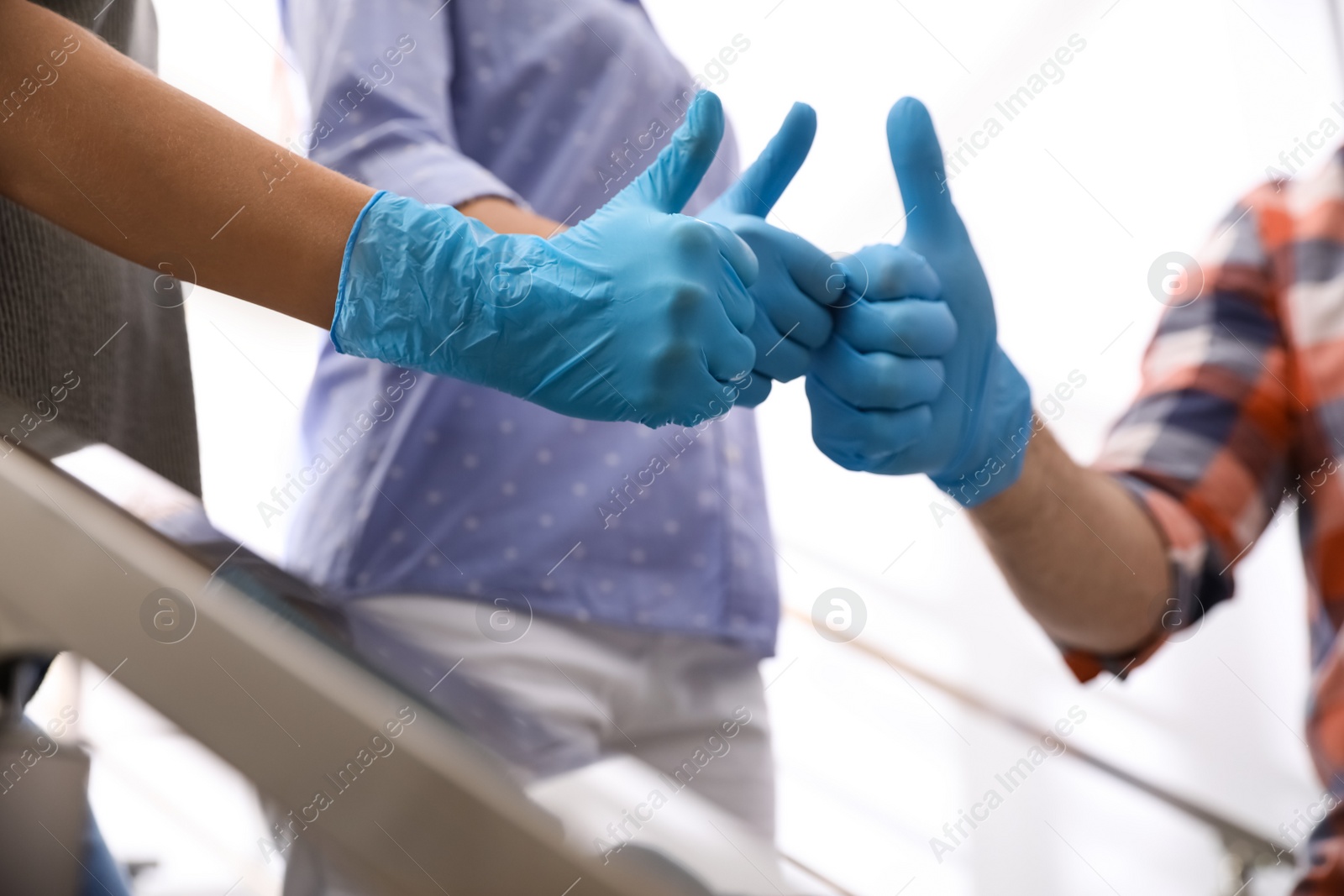 Group of people in blue medical gloves showing thumbs up on light background, closeup Photo of Group of people in blue medical gloves showing thumbs up on light background, closeup