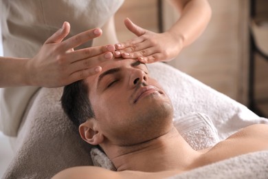 Photo of Man receiving facial massage in beauty salon
