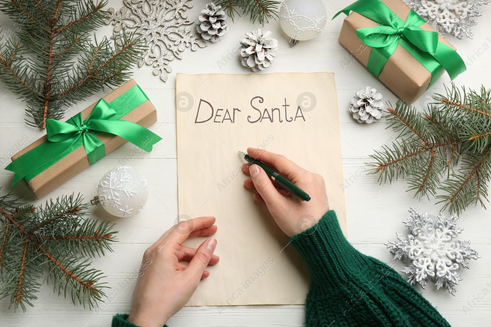 Top view of woman writing letter to Santa at white wooden table, closeup Photo of Top view of woman writing letter to Santa at white wooden table, closeup
