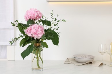 Beautiful pink hortensia flowers in vase on kitchen counter. Space for text Photo of Beautiful pink hortensia flowers in vase on kitchen counter. Space for text