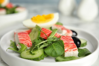 Delicious crab stick salad on white plate, closeup Photo of Delicious crab stick salad on white plate, closeup