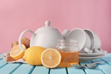 Lemons, jar with honey and crockery on table Photo of Lemons, jar with honey and crockery on table