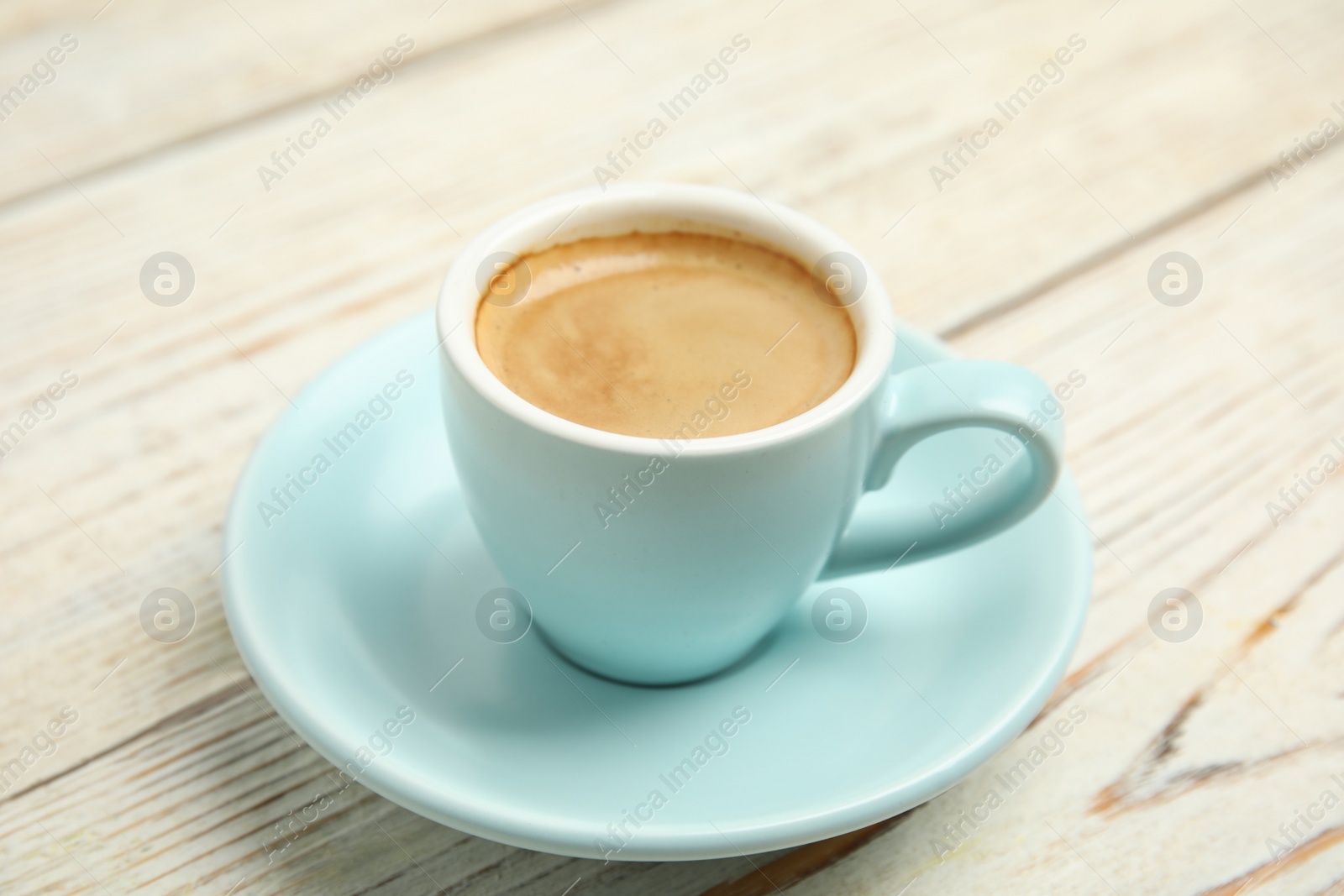 Cup of tasty coffee on white wooden table, closeup Photo of Cup of tasty coffee on white wooden table, closeup