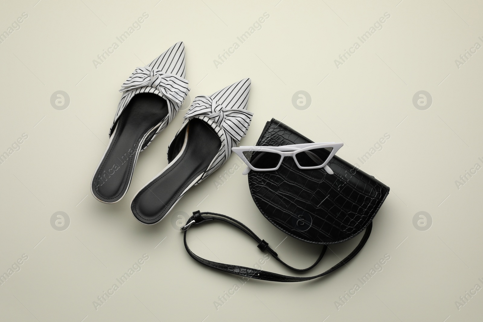 Stylish woman's bag, shoes and sunglasses on light background, flat lay Photo of Stylish woman's bag, shoes and sunglasses on light background, flat lay