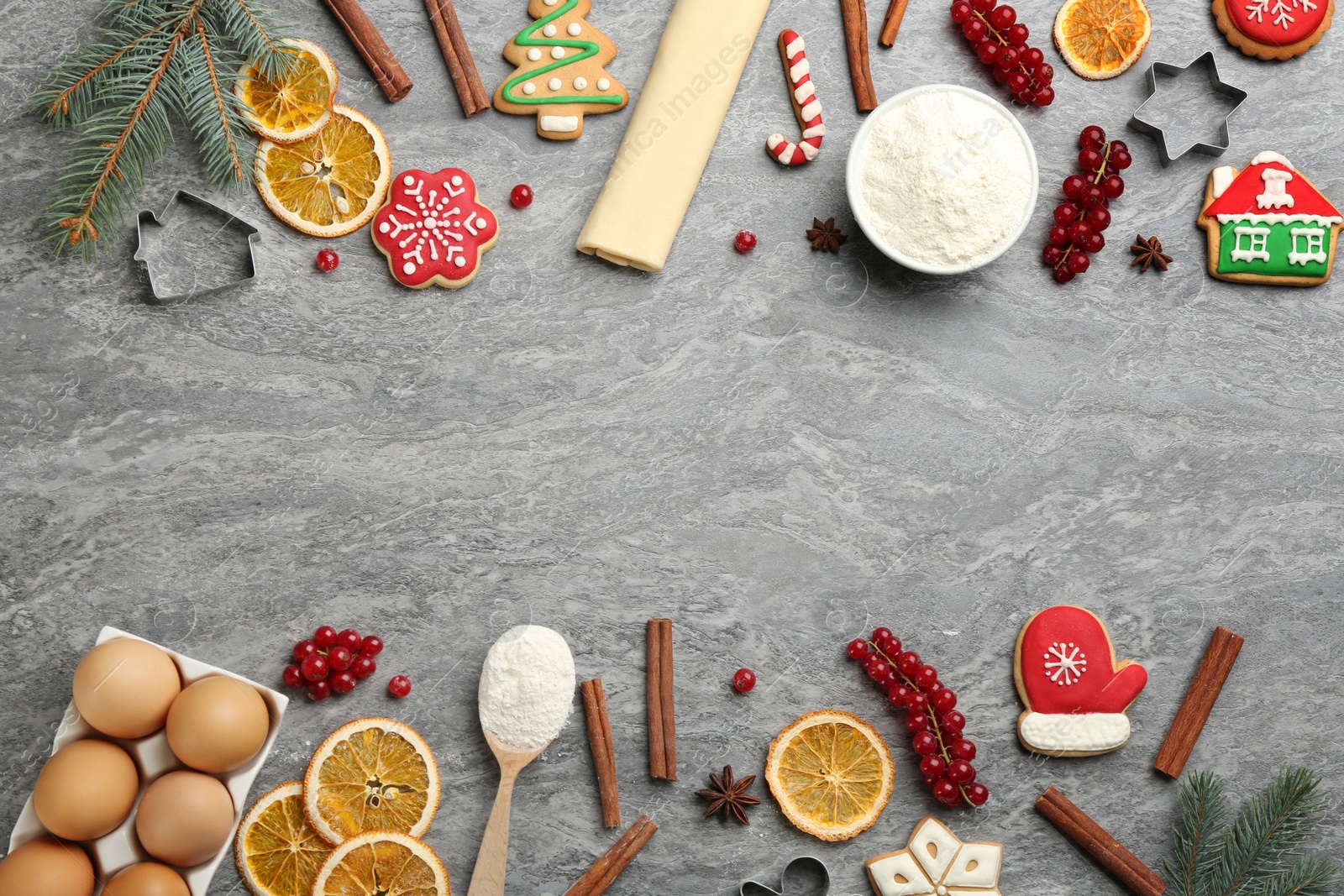 Frame of Christmas cookies and flour on grey table, flat lay. Space for text Photo of Frame of Christmas cookies and flour on grey table, flat lay. Space for text