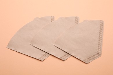 Paper coffee filters and beans on beige background, flat lay Photo of Paper coffee filters and beans on beige background, flat lay