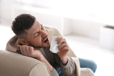 Photo of Man suffering from runny nose at home