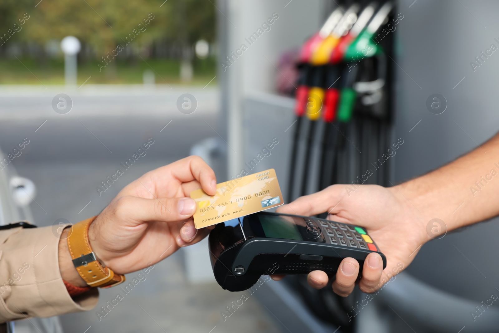 Man sitting in car and paying with credit card at gas station, closeup Photo of Man sitting in car and paying with credit card at gas station, closeup