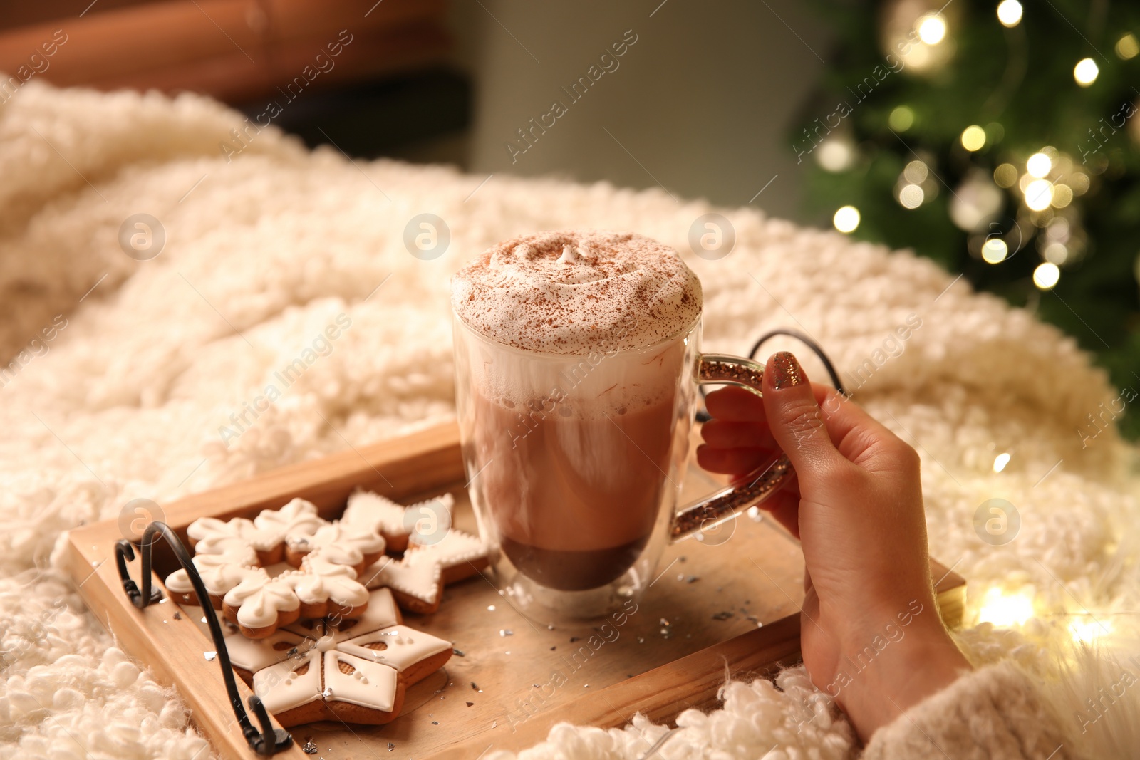 Photo of Woman with cup of hot drink and Christmas cookies at home, closeup