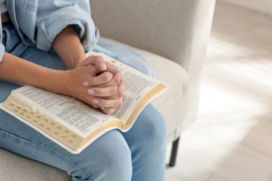 Religious woman with Bible praying indoors, closeup. Space for text Photo of Religious woman with Bible praying indoors, closeup. Space for text